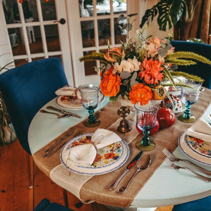 Dining room decorated for autumn / fall holidays. Thanksgiving or autumn harvest with warm tones and velvet chairs.